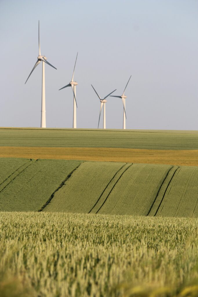 Wind turbines in the countryside generate eco-friendly energy amid vast fields.